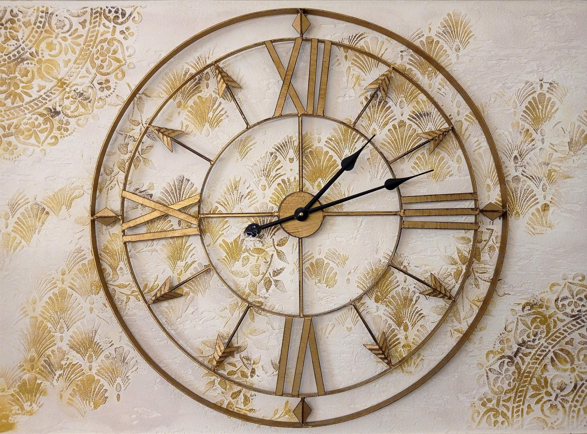 Elegáns faldekoráció arany órával és ornamentális mintával